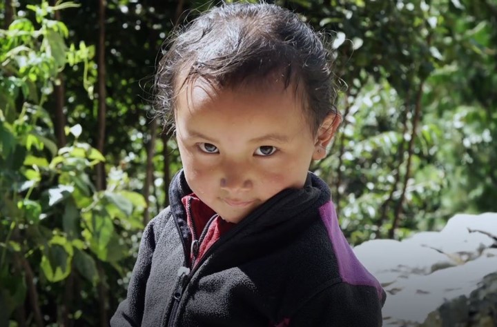 In Nepal, a young child smiles shyly