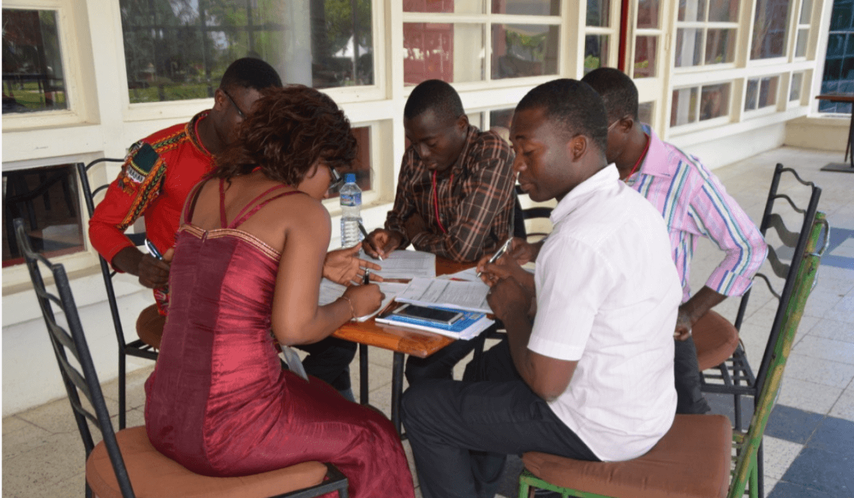 A group of people sit around a table reviewing documents
