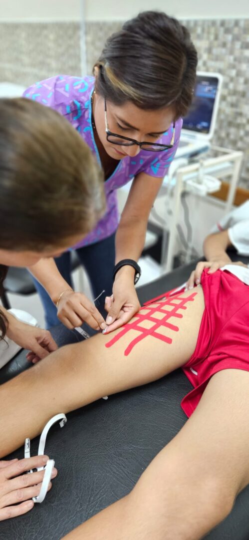 An IHTC fellow is demonstrating physiotherapy techniques.